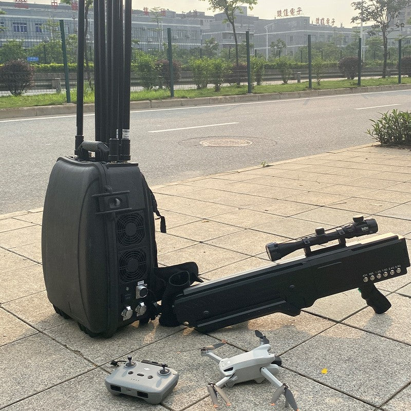 Black electronic device with antennas on a sidewalk, surrounded by small objects.